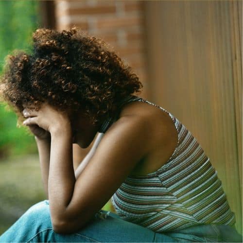 Depressed woman with head in hands