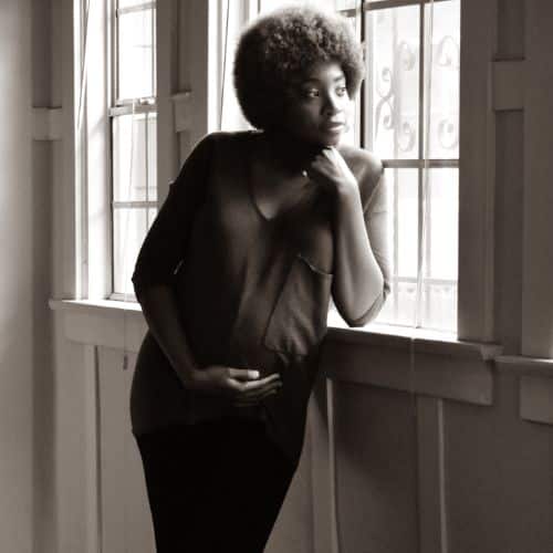 pregnant Black woman looking out window